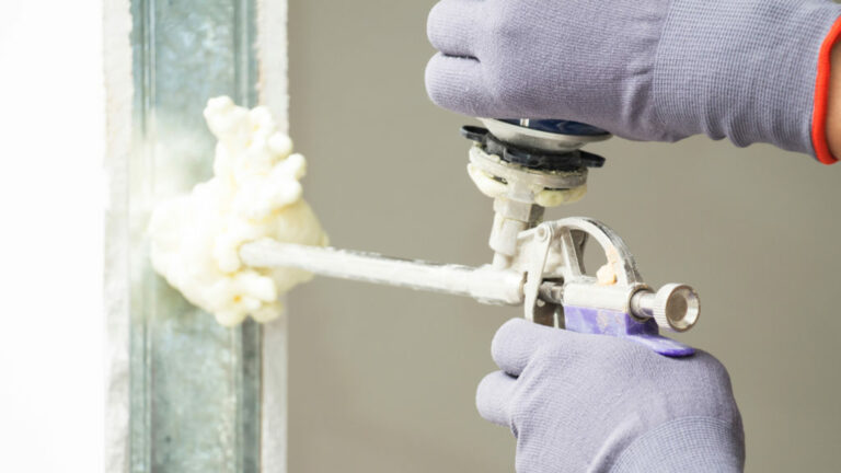Close-up of a foam spray gun spraying foam to seal a wall
