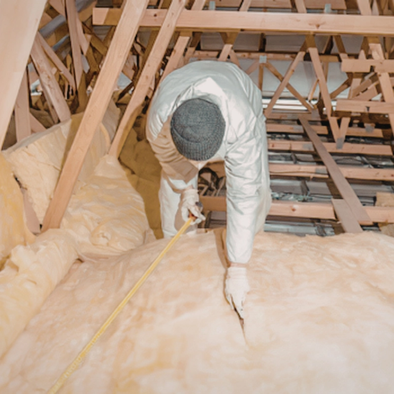 Builder installing fibreglass home insulation